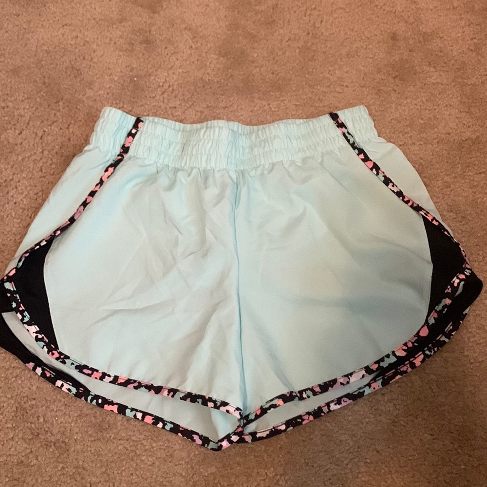 Teal athletic shorts , with black , white , pink , orange , and purple rim .